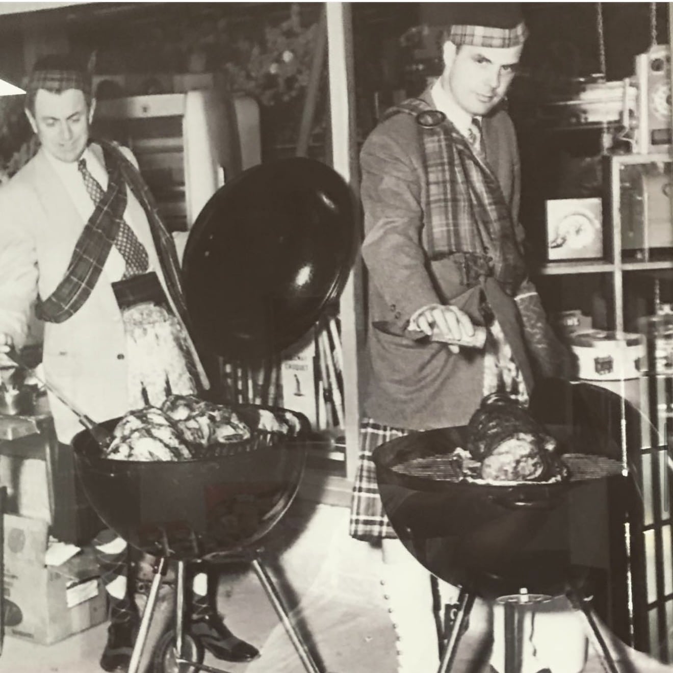 Old black and white photo of two people grilling