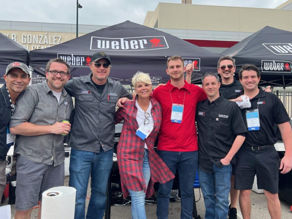 Group photo in front of a Weber grill tent