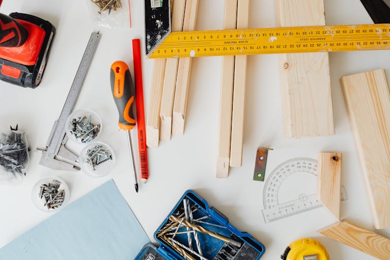 Top view of carpentry tools and wooden planks neatly arranged for a project.